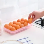 Canasta plástica rosada para 15 huevos, vista superior con mano colocando un huevo.