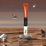 Reparador labial Luxkin Champagne 10g, naranja, con colágeno y ácido hialurónico, sobre pedestal gris con diamantes.