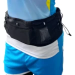Riñonera deportiva negra con compartimento transparente para correr, usada por persona con camiseta azul y shorts azules.