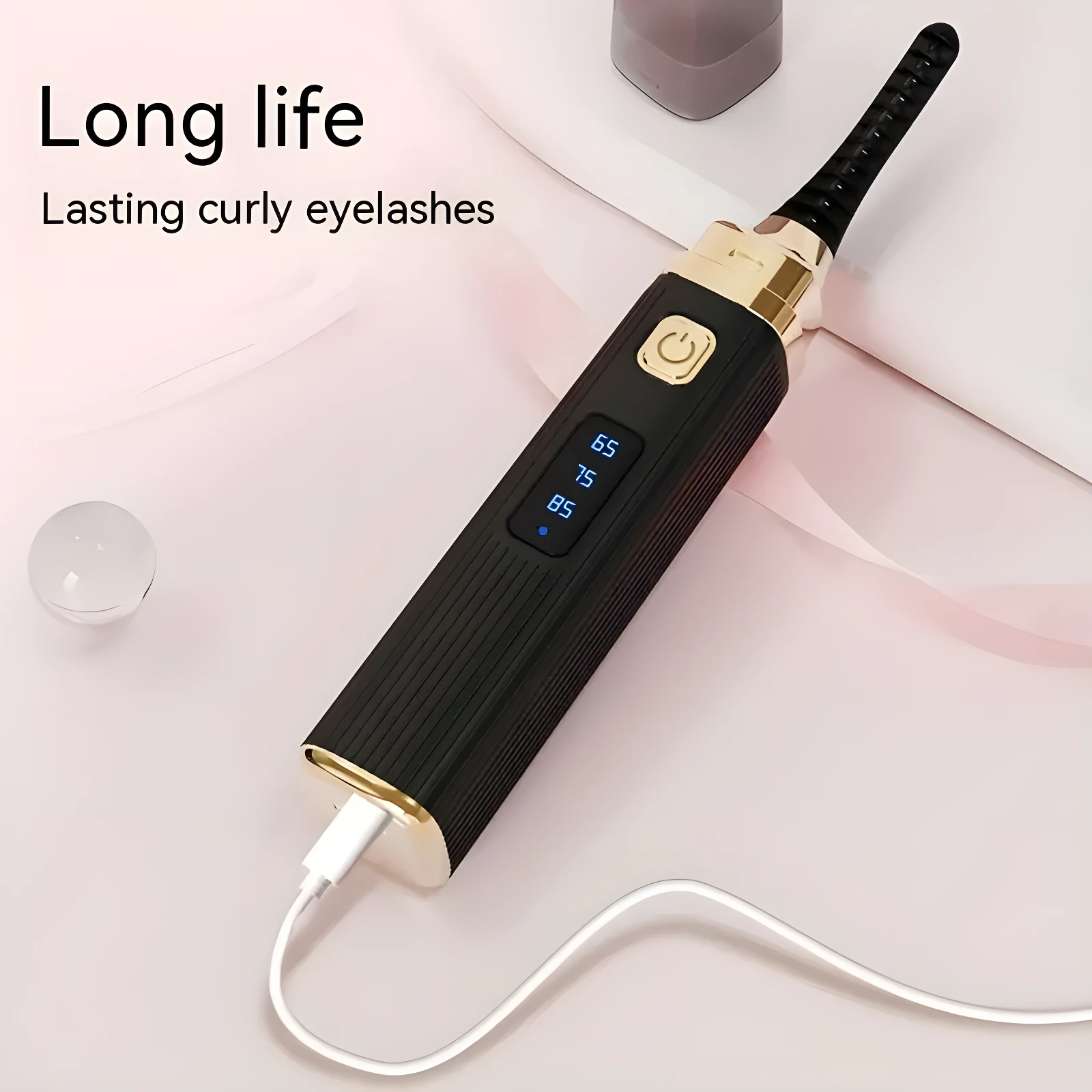Rizador eléctrico de pestañas negro y dorado con pantalla LED de temperatura (65-85°C) y cable USB.