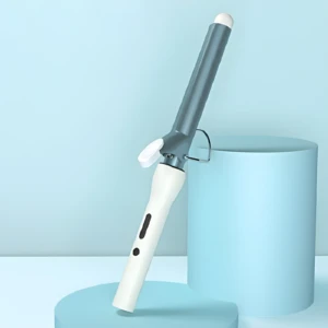 Rizador de cabello blanco y azul metálico con pinza de sujeción, apoyado sobre plataformas circulares en un fondo minimalista color azul claro.