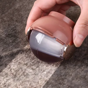 Rodillo quita motas portátil rosa y transparente, ideal para textiles impecables al instante.