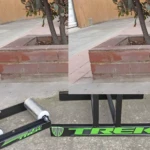 Rodillo de entrenamiento para bicicleta Trek en color negro con detalles verdes, diseño portátil y estable, ideal para ciclismo indoor.