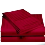 Sábanas rojas de satín con textura de rayas, apiladas y dobladas.