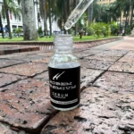 Serum Hobem Premium Aclarante, frasco con gotero sobre ladrillos, ideal para manchas y piel sensible.