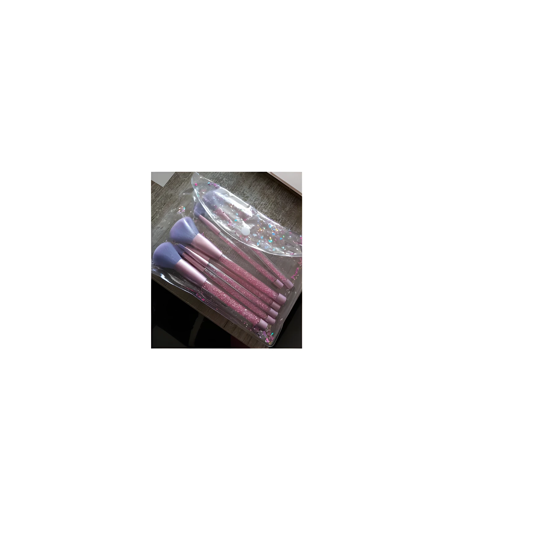 Set de 12 brochas de maquillaje con mangos rosas brillantes y cerdas moradas, en bolsa transparente con confeti.