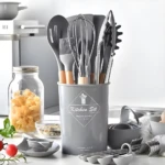 Set de 12 utensilios de cocina grises con mangos de madera, soporte, batidor y pinzas en primer plano.