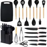 Set de 19 utensilios de cocina negros con mangos de madera, incluye tabla, cuchillos, espátulas, batidor, pinzas y organizador para mesón.