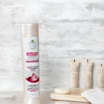 Shampoo Evolución Natural con extracto de cebolla, sin sal ni parabenos, en botella blanca de 350ml, junto a jabones y cremas.