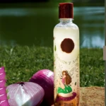 Shampoo S.O.S Ritual Botánico, botella transparente con tapa roja, contiene cebolla y argán, para cabello seco y dañado.