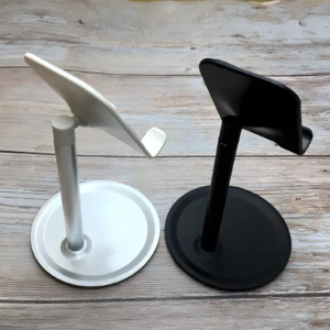 Soporte para celular en aluminio, uno blanco y otro negro, con base circular, ideales para mesa.