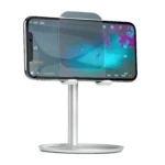 Soporte de celular plateado en aluminio con pantalla de video, base redonda y brazo ajustable.