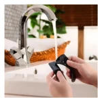 Soporte celular multiusos Fixate Gel P en negro, pegado a lavamanos con agua y toallas.