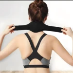 Soporte cervical negro para terapia, ajustable en cuello y parte superior de la espalda, usado por mujer.