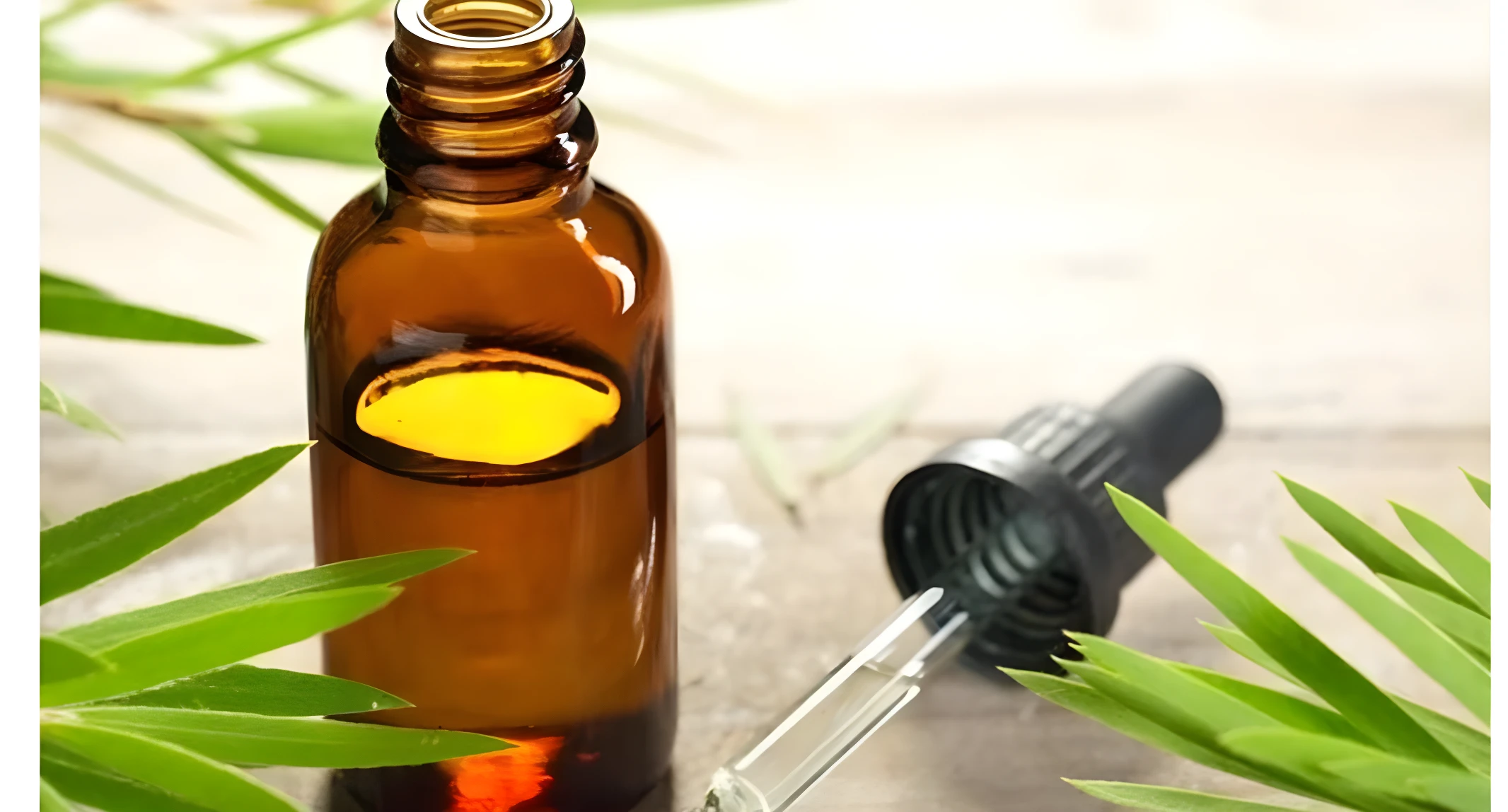 Frasco de vidrio ámbar con suero capilar y gotero separado sobre superficie de madera, rodeado de hojas verdes frescas para resaltar el origen natural.