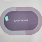 Tapete antideslizante para baño, color morado con bordes degradados, con etiqueta de marca.
