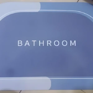 Tapete absorbente antideslizante para baño en tonos azules con borde blanco y la palabra "BATHROOM" inscrita.
