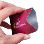 Mano sujetando protector RFID de aluminio color borgoña con patrón de rombos y logo de bloqueo.