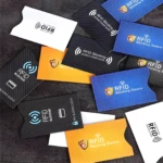Tarjeteros RFID de aluminio con protección contra robo en diversos colores: blanco, naranja, azul y negro.