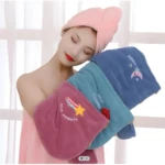 Mujer con turbante rosa y toallas de microfibra azules y rosadas con diseños de estrellas y arcoíris.