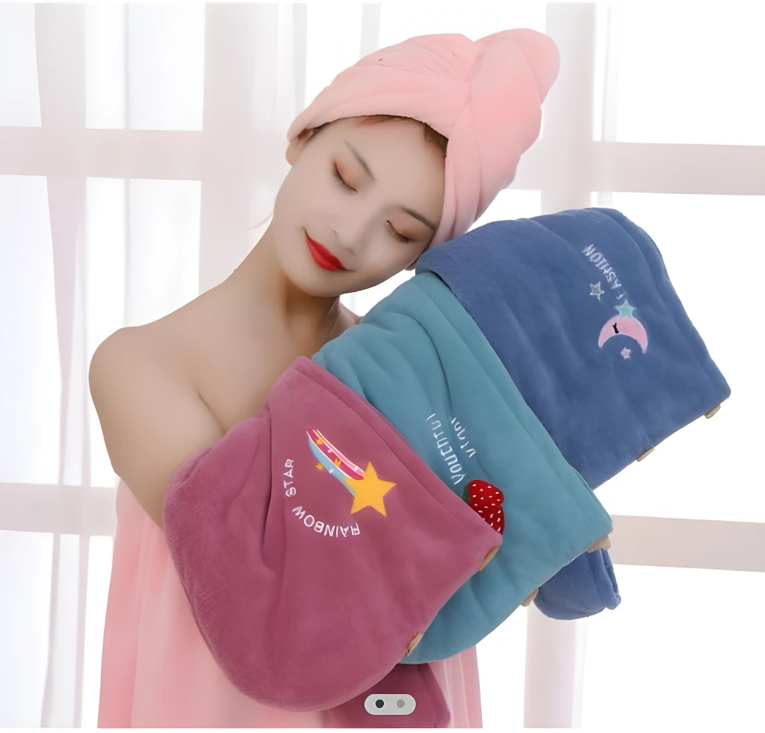 Mujer con turbante rosa y toallas de microfibra azules y rosadas con diseños de estrellas y arcoíris.