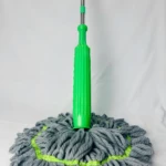 Trapero giratorio verde con tiras de microfibra grises para limpieza de suelos.