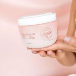 Crema capilar rosa Murena Tratamiento Nutritivo Hidratación Brillo 350 ml en manos con uñas pintadas.