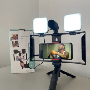 Trípode portátil con soporte para celular, micrófono y dos luces LED cuadradas, ideal para video y audio.