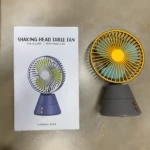 Ventilador de mesa recargable giratorio con rejilla amarilla, aspas azules y base gris.