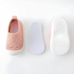 Zapato de bebé rosa de tela con suela blanca, plantilla interior y plantilla de goma.