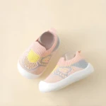Zapatos infantiles rosados con suela blanca, diseño de malla transpirable con detalles en amarillo y gris, para correr.