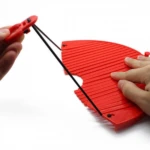 Colador Better Strainer rojo flexible con sistema de ajuste para escurrir pasta.