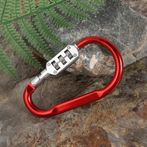 Carabina roja con candado de combinación de 3 dígitos, sobre rocas y follaje.