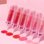 Voluminizador de labios HANDAIYAN en forma de jeringa, varios tonos rosados y rojos, brillo líquido y textura suave.
