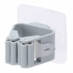 Gancho gris con rodillos de sujeción y adhesivo transparente para colgar escobas y trapeadores.