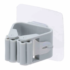 Gancho gris con rodillos de sujeción y adhesivo transparente para colgar escobas y trapeadores.