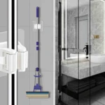 Colgador blanco doble para mopa y escoba con soporte de pared, ideal para organizar utensilios de limpieza en el hogar.