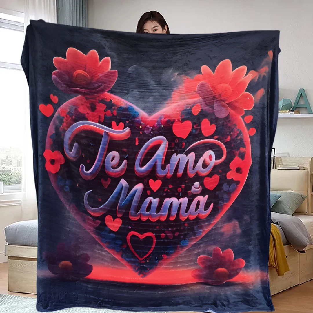 Manta de felpa polar con diseño de corazón rojo y texto Te Amo Mama, sostenida por una persona en interior.