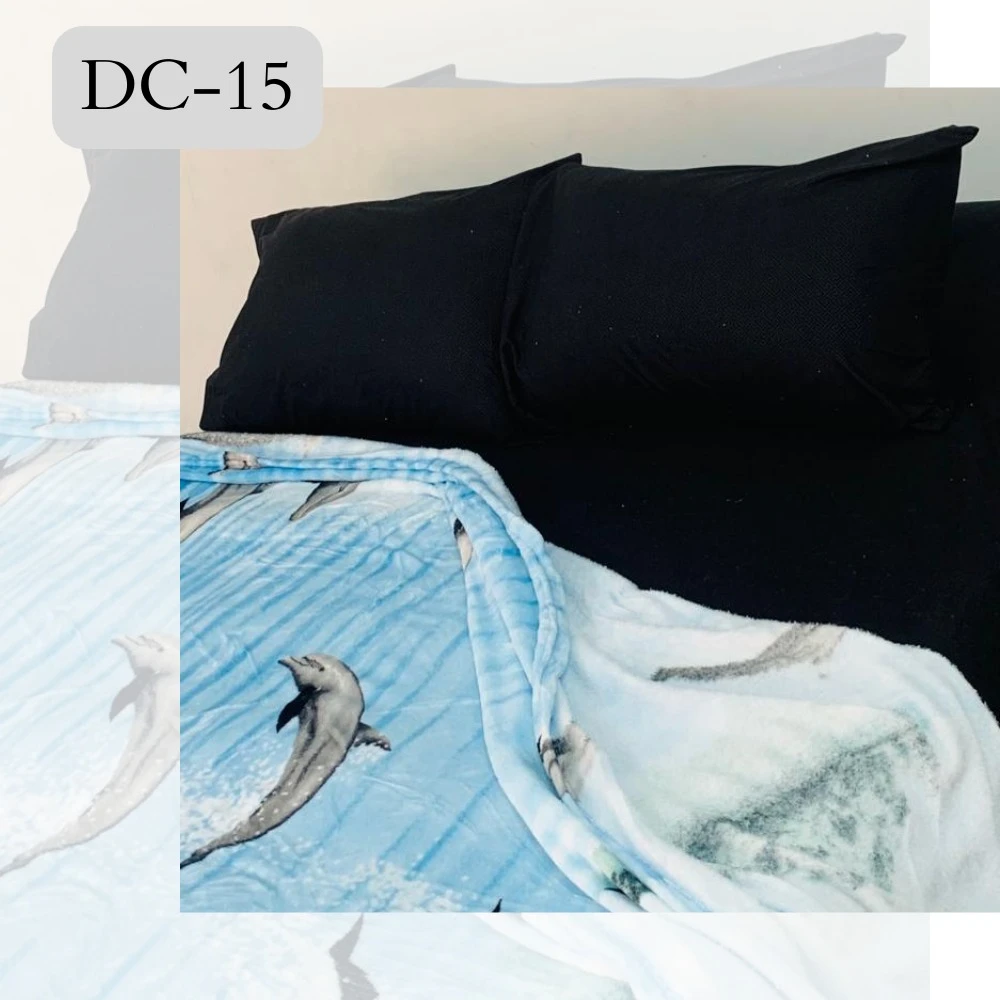Cobija semitérmica suave con estampado de delfines en el mar, sobre cama con almohadas negras.