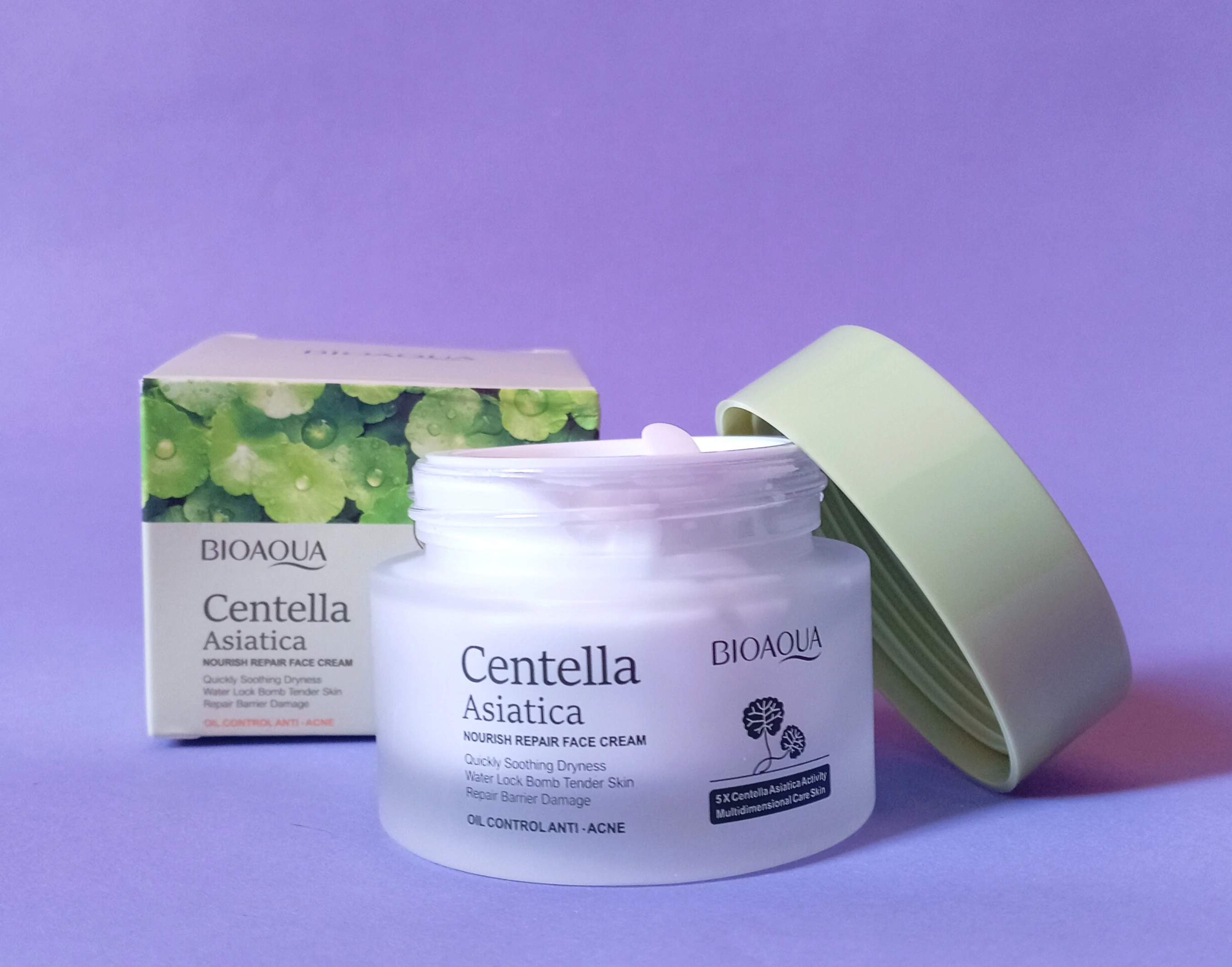 Crema facial BIOAQUA Centella Asiática en frasco blanco con tapa verde, caja con hojas verdes al fondo.