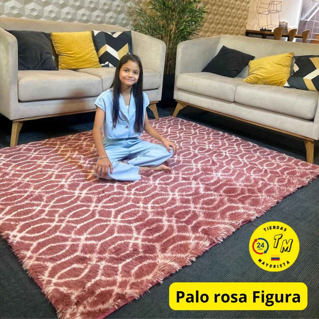 Alfombra peluda rosa con figura geométrica, colocada en sala entre dos sofás, ideal para uso doméstico y decoración cálida.