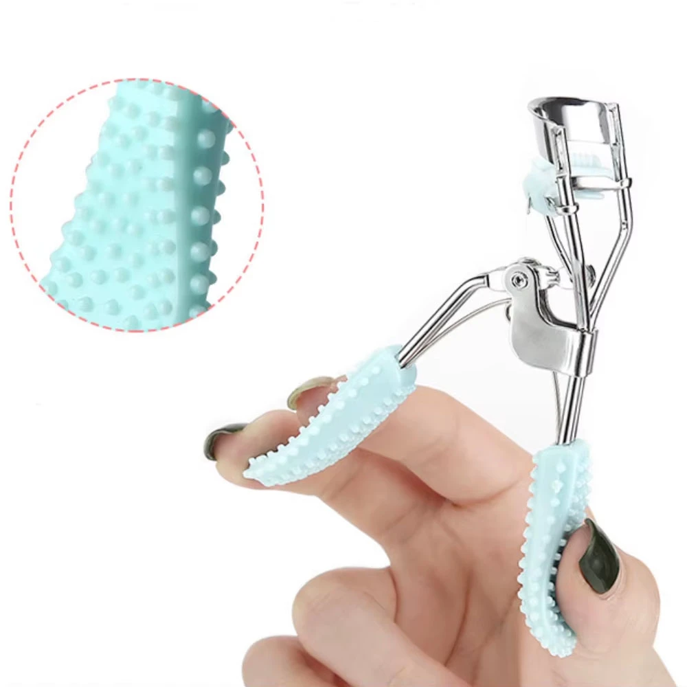 Encrespador de pestañas manual azul con textura de puntos y pomo de maquillaje en mano.
