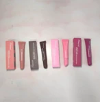 Cajas y tubos de Peptide Lip Tint R1642 en tonos rosa, marrón y fucsia sobre superficie clara.