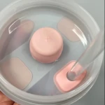 Kit antiderrame Stanley con tapa rosada y sorbete transparente en recipiente con agua.