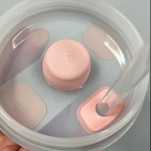 Kit antiderrame Stanley con tapa rosada y sorbete transparente en recipiente con agua.