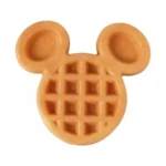 Waflera antiadherente en forma de cabeza de Mickey Mouse, color dorado, con textura de cuadrícula clásica y orejas redondeadas.