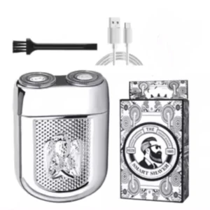 Mini afeitadora eléctrica plateada con dos cabezales, cepillo y cable USB-C, junto a su caja con diseño vintage.