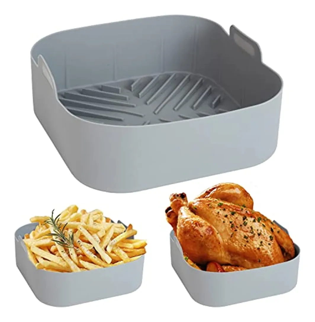 Molde de silicona gris para freidora con asas, mostrando pollo y patatas fritas drenando aceite.