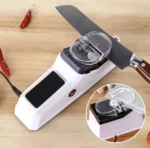 Afilador eléctrico USB blanco con cuchillo en uso y chiles secos al lado.