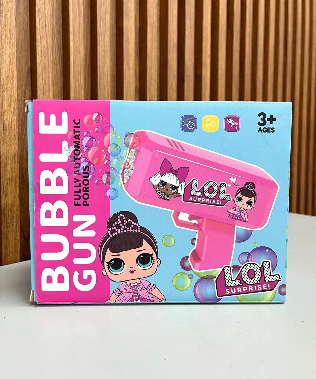 Caja de la pistola de burbujas automática Lol Surprise en color rosa, con de personaje y burbujas flotantes.